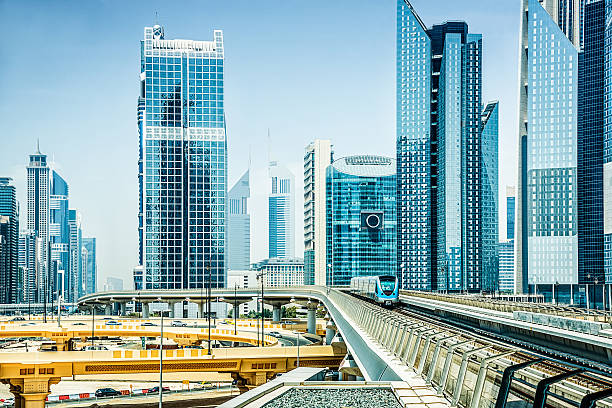 Modern high-rise buildings in Dubai with a metro train in the foreground, representing real estate opportunities.